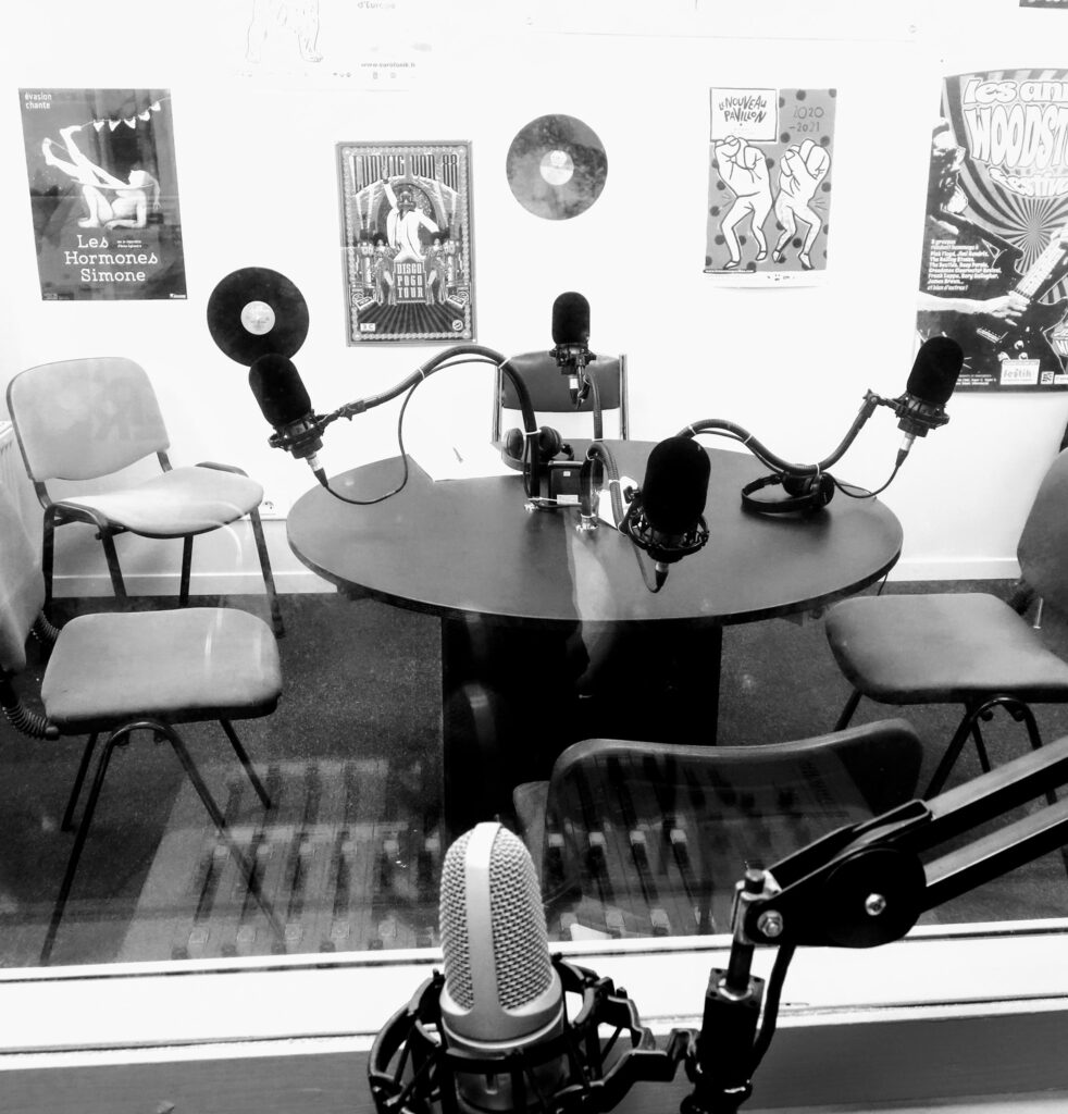 photo d'un studio d'enregistrement de radio avec des chaises et des micros sur une table
