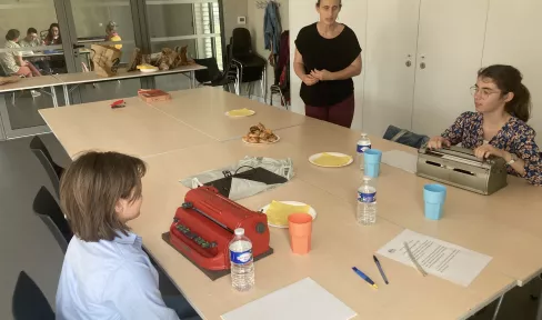 photo de 3 personnes autour d'une table devant des machines à écrire en braille