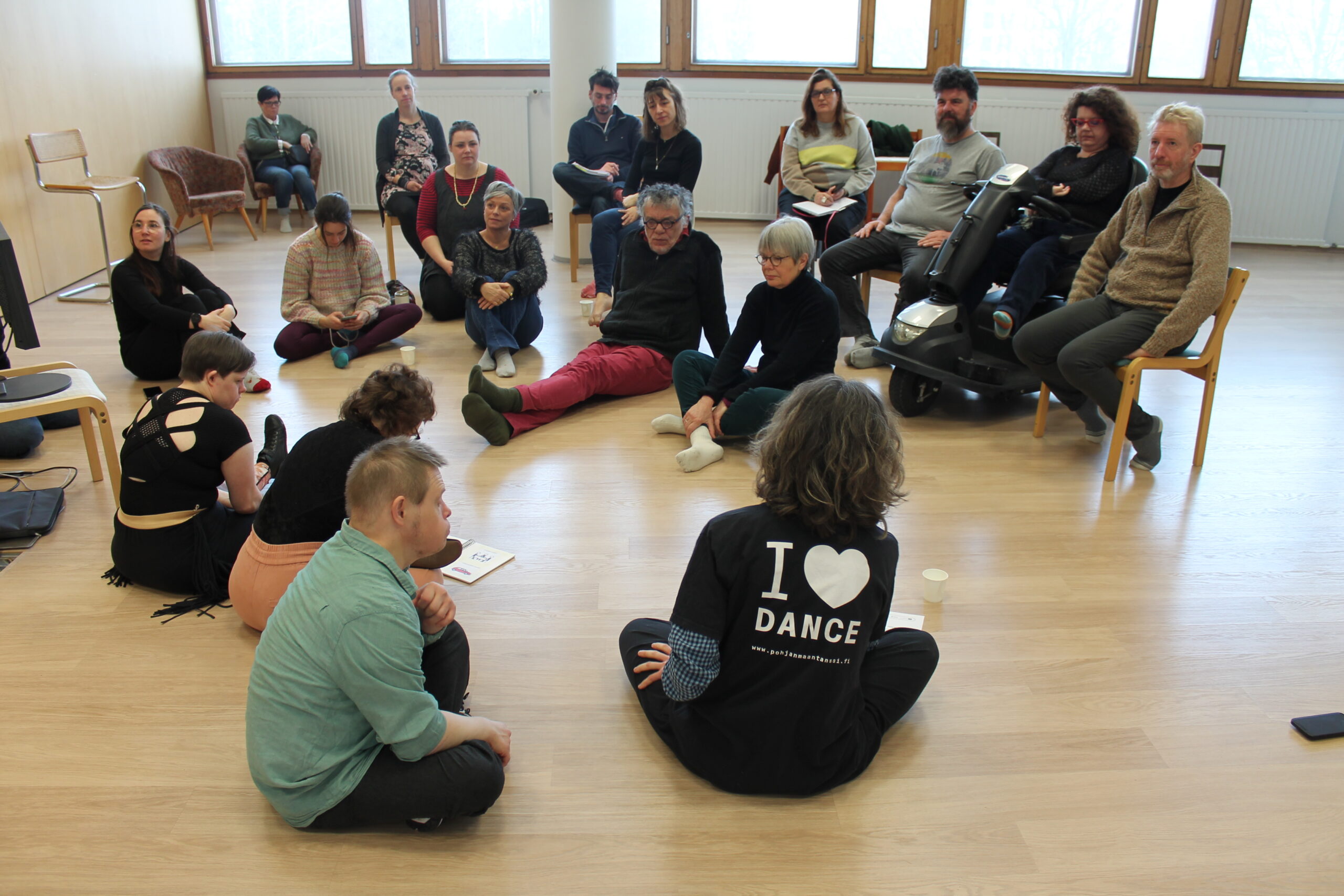 12 personnes assises dans une salle de danse