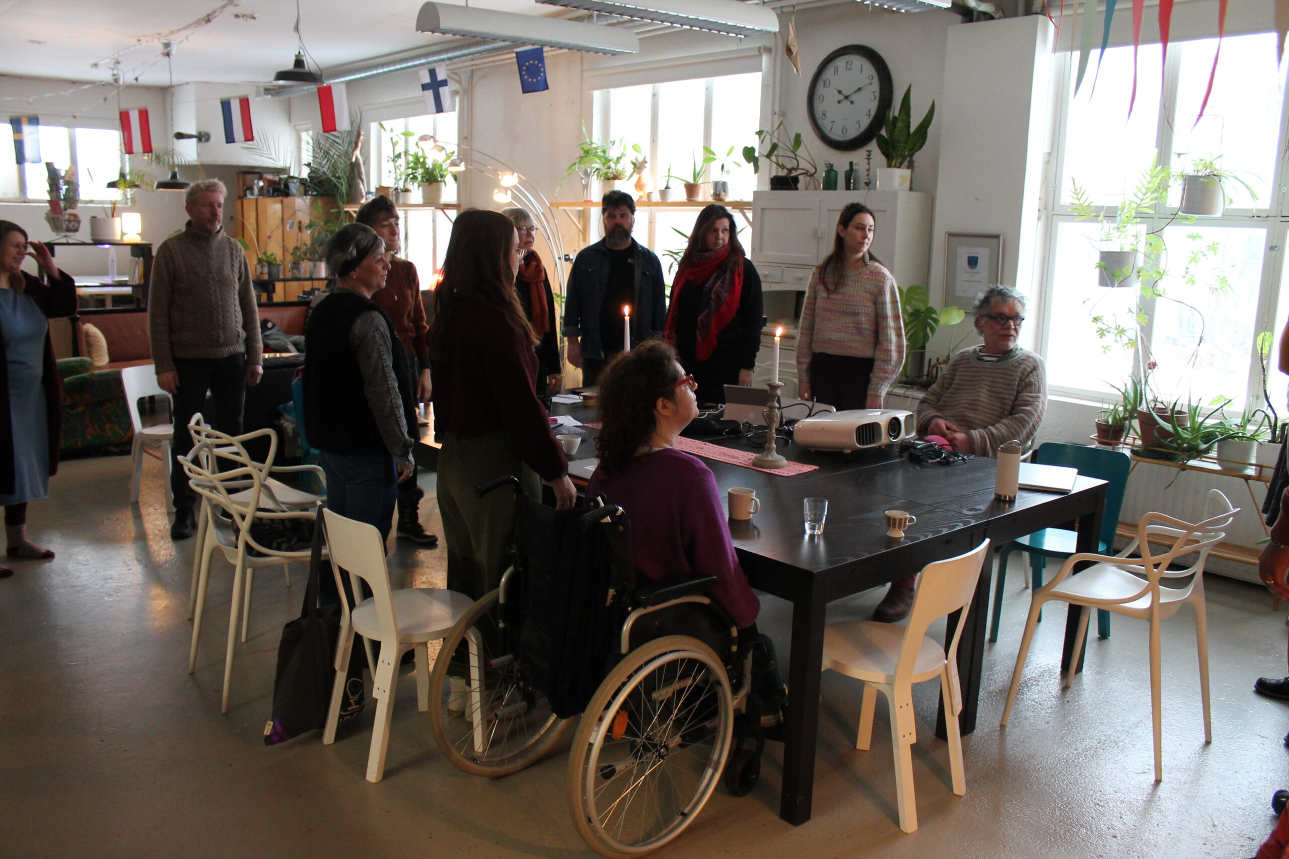 13 personnes debout autour d'une table